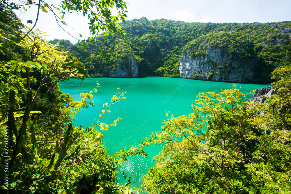 Scenery emerald lagoon situated in the middle of the limestone mountain.