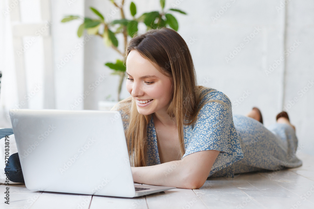 Portrait of a beautiful young woman smiling and social networking using a laptop and wireless connection Portrait of a beautiful young woman smiling and social networking using a laptop and wireless connection