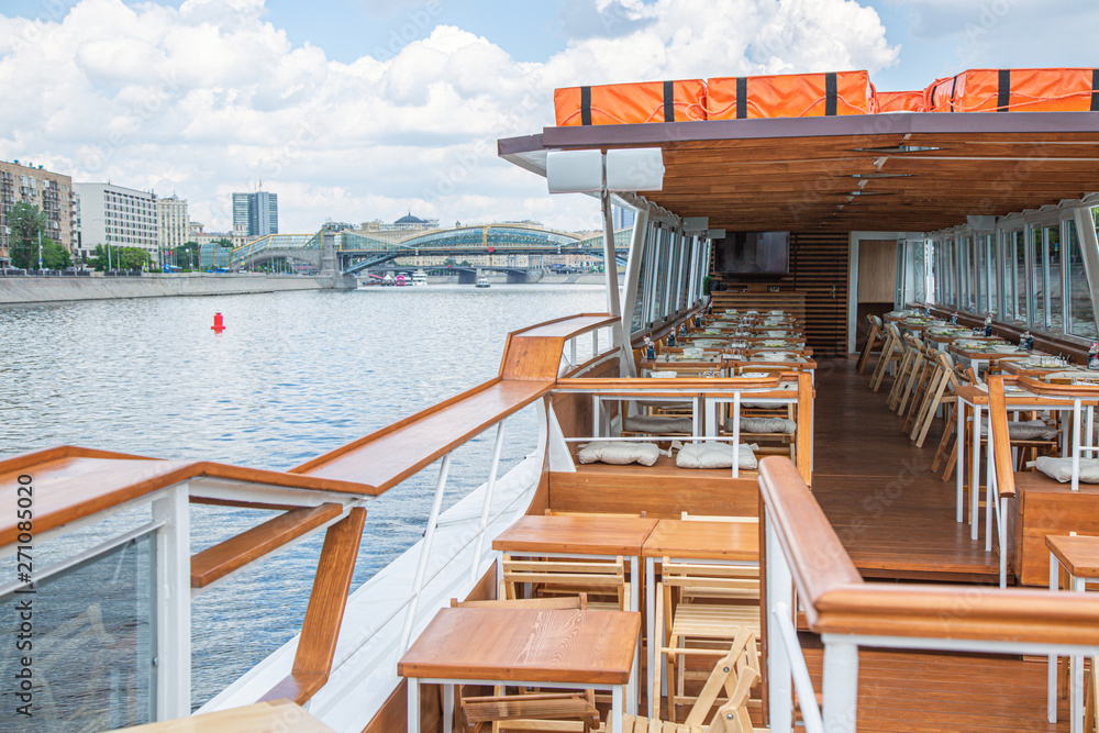 The interior of the urban river ship, with a panoramic view of the urban landscape. The concept of tourism, recreation, walking around the city, rest in the city. River transport. The interior of the urban river ship, with a panoramic view of the urban landscape. The concept of tourism, recreation, walking around the city, rest in the city. River transport.