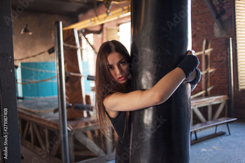 Girl fighter Boxing with punching bag, a young woman trains in the gym.