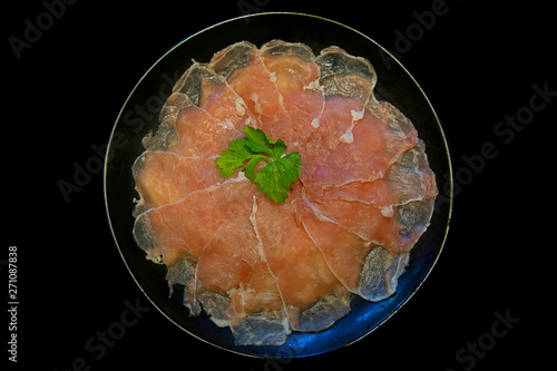 Top view of pork slice put in black plate