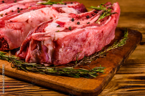 Raw pork ribs with spices and rosemary on a cutting board