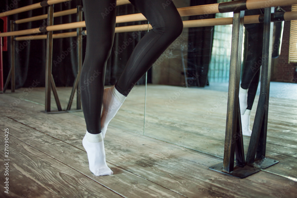 Obraz premium girl the dancer next to a ballet bar, Legs close up