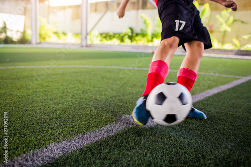 Fototapeta Naklejka Na Ścianę i Meble -  blurry ball after boy soccer player speed run on green artificial turf to shoot it to goal.