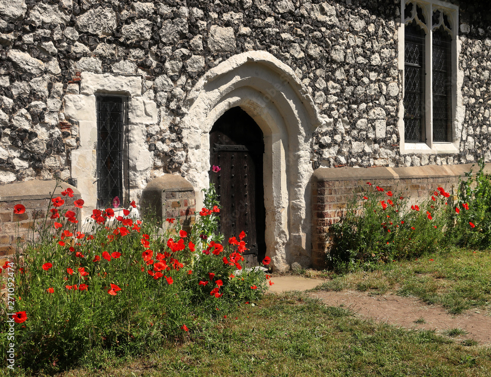 Red Poppies around an English village church doorway