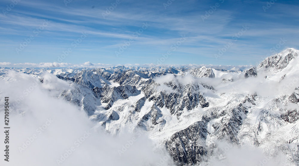 Panoramic view from a high point on the snow-covered mountain range. Mountain Altai.