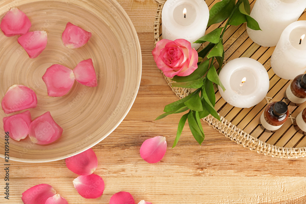 Flat lay composition with bowl of water, rose petals and candles on table. Spa treatment Flat lay composition with bowl of water, rose petals and candles on table. Spa treatment