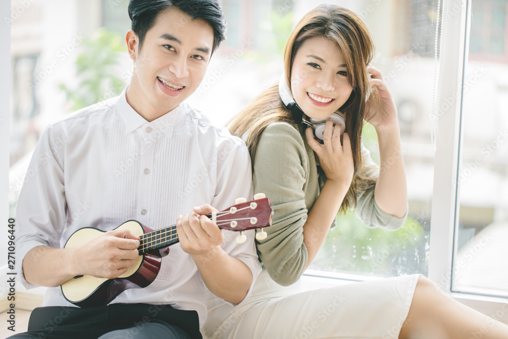 Couples of asian younger men and women playing guitar with relaxing and happiness emotion.