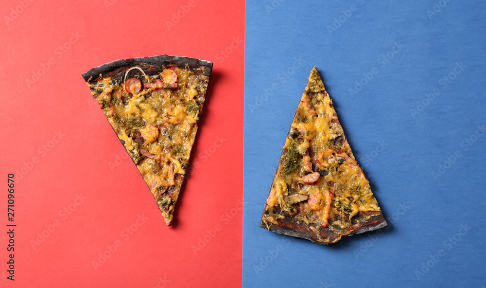 Fototapeta Slices of black pizza on color background, flat lay