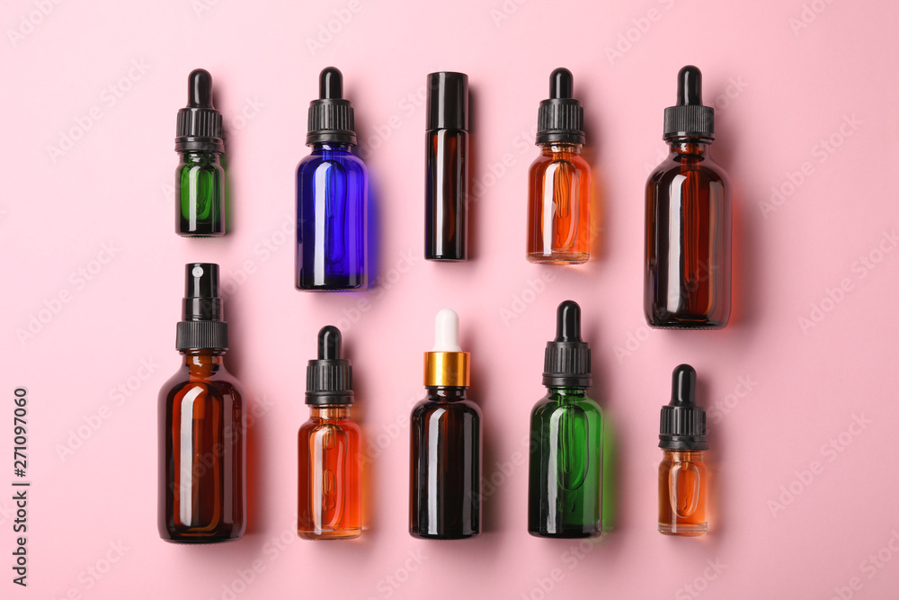 Bottles of essential oils on color background, flat lay. Cosmetic products Bottles of essential oils on color background, flat lay. Cosmetic products