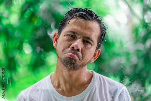 Sad young Asian man standing outdoors during rain  © anut21ng Stock