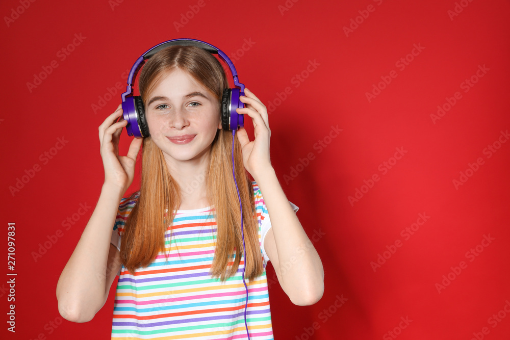 Teenage girl enjoying music in headphones on color background. Space for text Teenage girl enjoying music in headphones on color background. Space for text