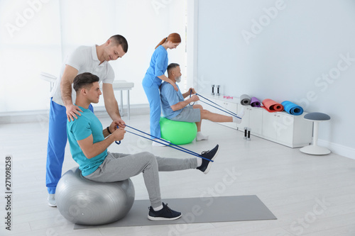 Fotografie Professional physiotherapists working with patients in rehabilitation center
