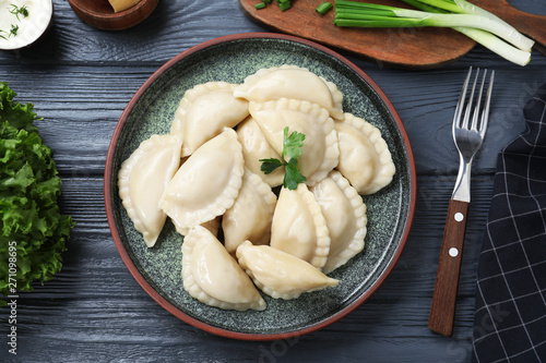 Flat lay composition with tasty dumplings served on wooden table photo