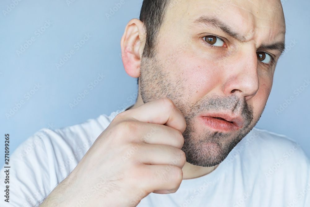 Obraz premium A man shaves in front a mirror. Shaving foam. Disposable razor.