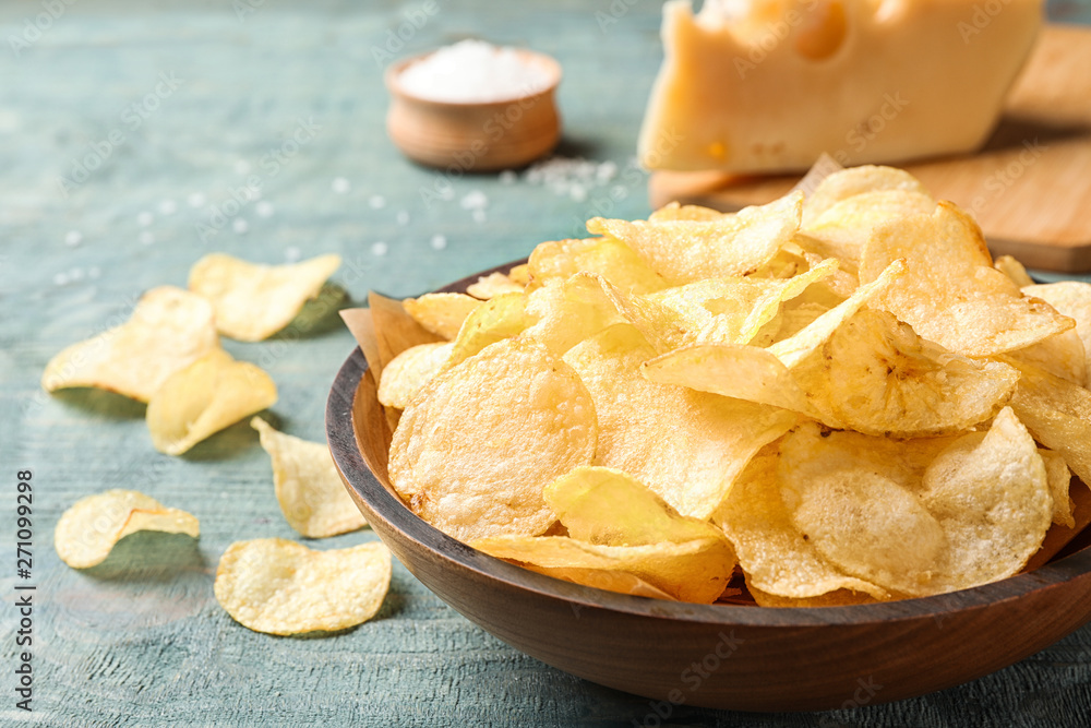 Delicious crispy potato chips in bowl on table, closeup with space for text Delicious crispy potato chips in bowl on table, closeup with space for text