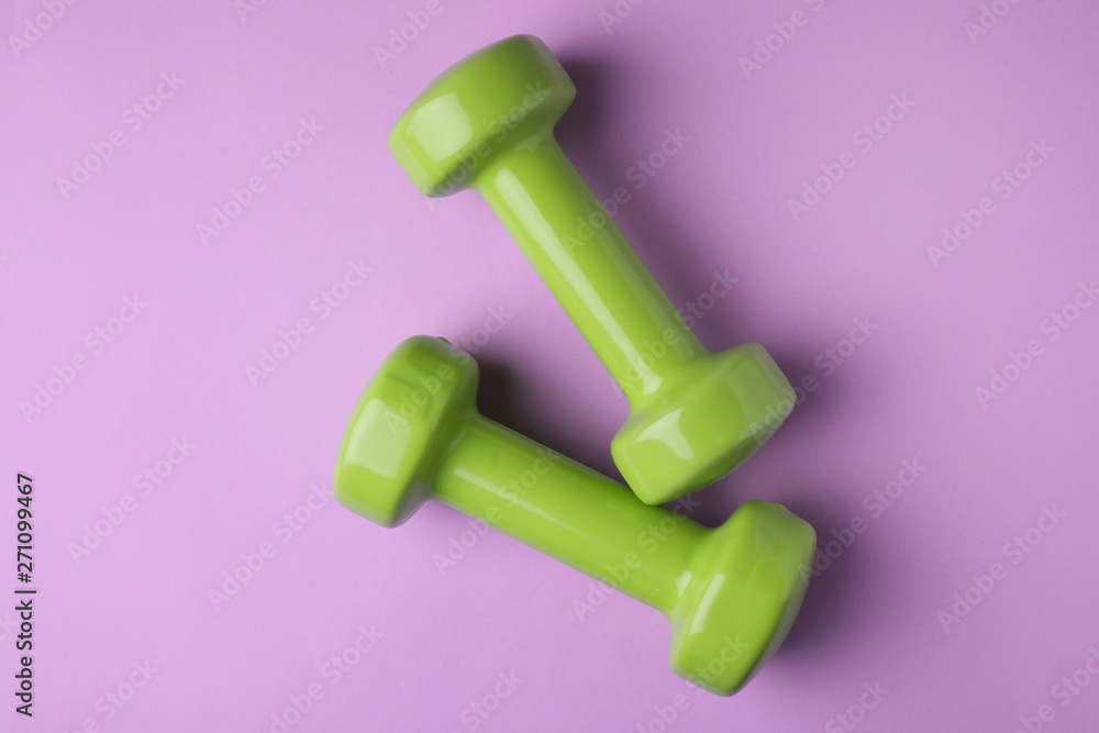 Bright dumbbells on color background, flat lay. Home fitness Bright dumbbells on color background, flat lay. Home fitness