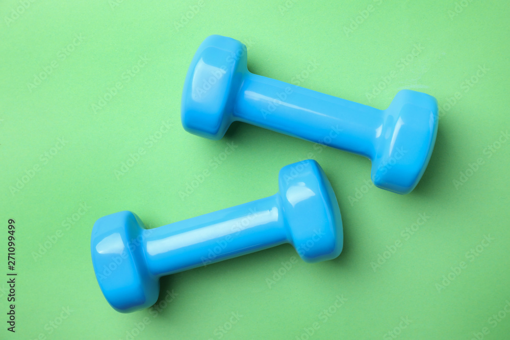 Bright dumbbells on color background, flat lay. Home fitness Bright dumbbells on color background, flat lay. Home fitness