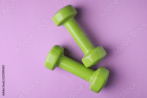Bright dumbbells on color background, flat lay. Home fitness