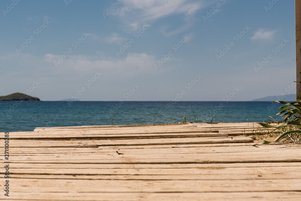 Fototapeta premium A wooden pathway leading to the beach, at the island of Andros, Cyclades, Greece