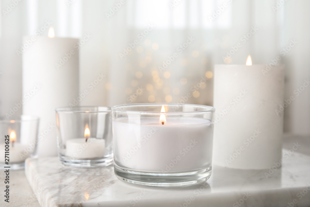 Burning aromatic candles in holders on table