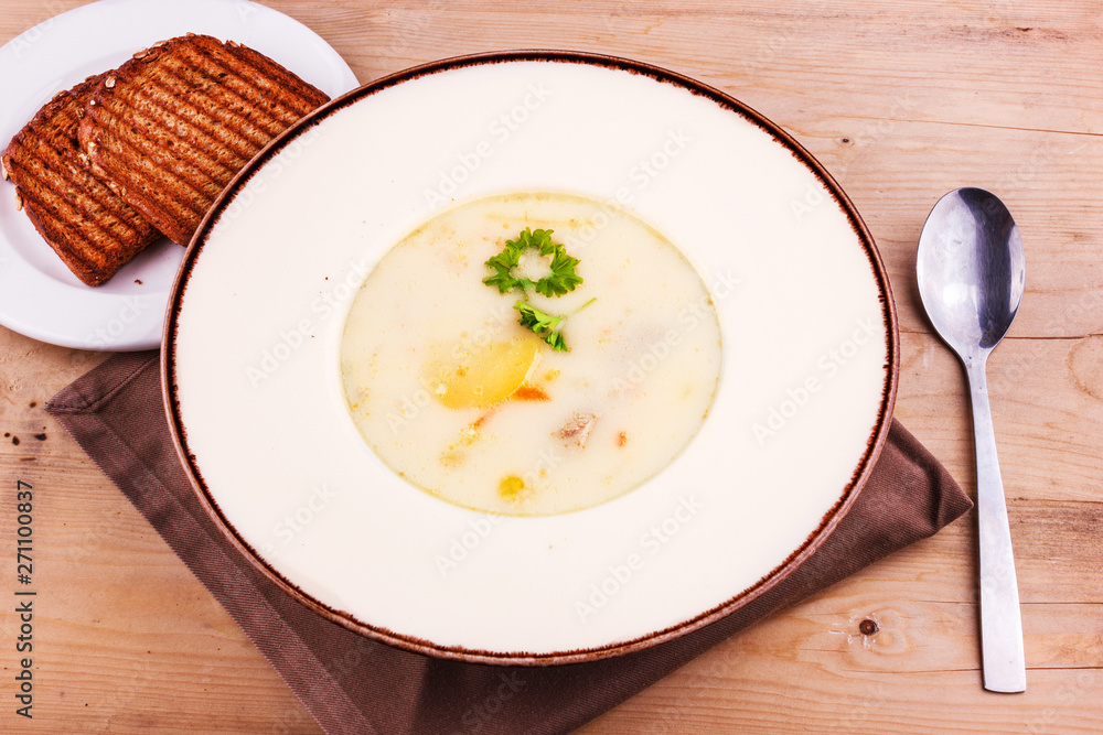 Cheese soup in a white plate with toasted bread Cheese soup in a white plate with toasted bread