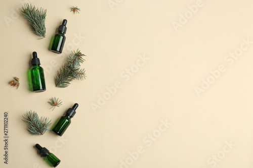 Flat lay composition with bottles of essential oil and space for text on color background