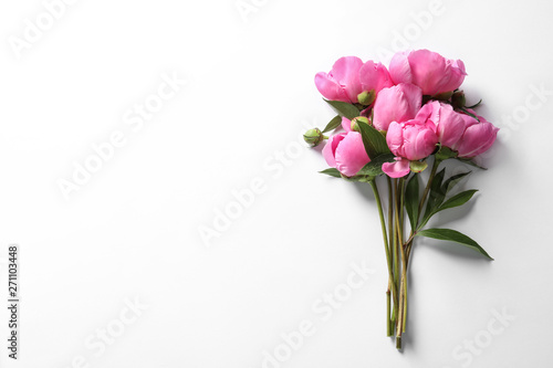 Fragrant peonies on white background, top view. Beautiful spring flowers