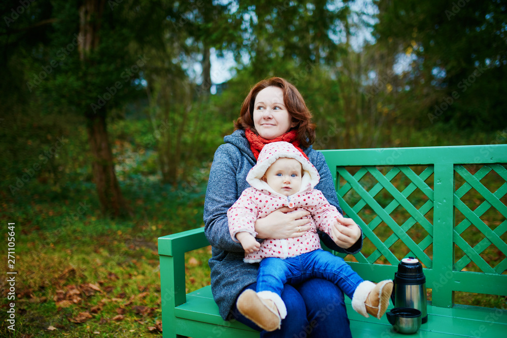 Mother and baby girl having a picnic in forest or park Mother and baby girl having a picnic in forest or park