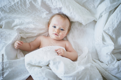 Cute little girl playing on bed