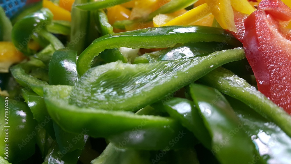 slices of colorful green, yellow, red, purple hot shiny Shimla chilli or peppers slices of colorful green, yellow, red, purple hot shiny Shimla chilli or peppers