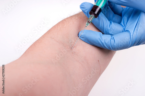 Nurse with blue rubber gloves using syringe suck blood at arm line on patient. Tests blood Healthcare checkup