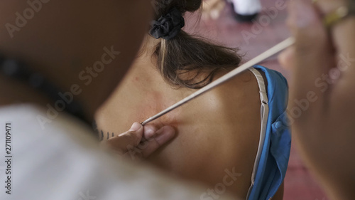 Wallpaper Mural Master makes traditional Yantra tattoo on magic tattoo Sak Yant holiday. Thailand. Torontodigital.ca