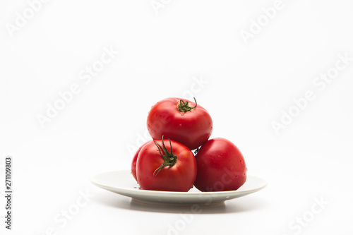  Red tomatoes in a plate on white background 