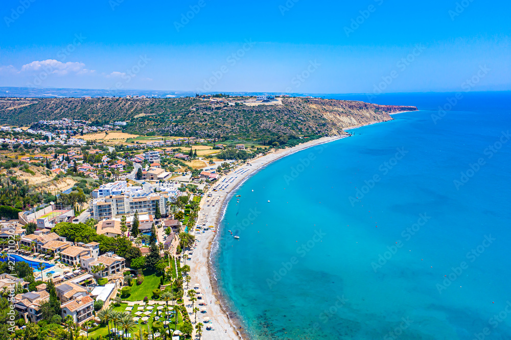 Pissouri. Cyprus. Pissouri beach panorama from a drone. Residential settlements and hotels in the valley at the mountains bottom. The Mediterranean blue lagoon. The Pissouri resort. Travel to Cyprus.