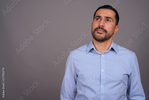 Handsome bearded Persian businessman against gray background © Ranta Images