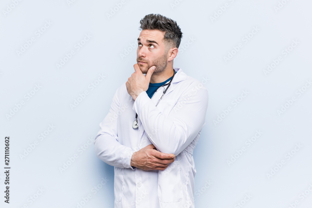 Young handsome doctor man looking sideways with doubtful and skeptical expression. Young handsome doctor man looking sideways with doubtful and skeptical expression.
