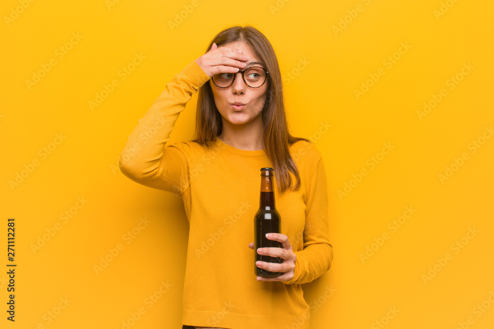Young pretty caucasian woman worried and overwhelmed. She is holding a beer. Young pretty caucasian woman worried and overwhelmed. She is holding a beer.