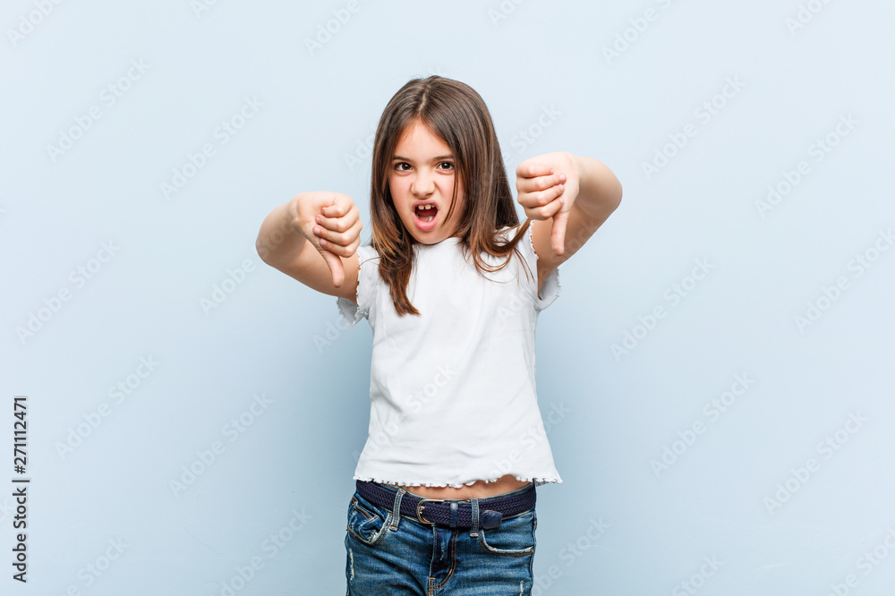 Cute girl showing thumb down and expressing dislike. Cute girl showing thumb down and expressing dislike.