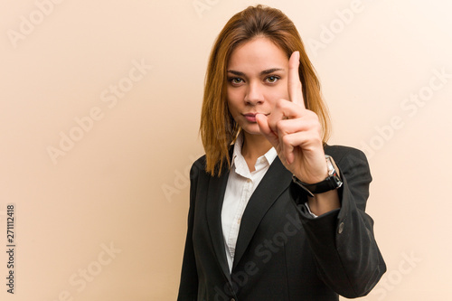 Young caucasian business woman showing number one with finger.