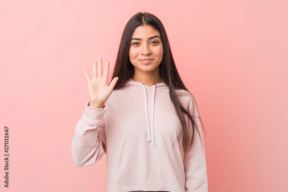Young pretty arab woman wearing a casual sport look smiling cheerful showing number five with fingers. Young pretty arab woman wearing a casual sport look smiling cheerful showing number five with fingers.