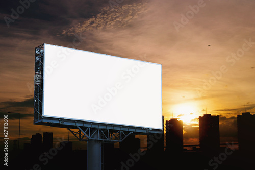 Blank billboard mockup with white screen against cloudy and city at sunset background. Copy space banner for advertisement. Business Concept.