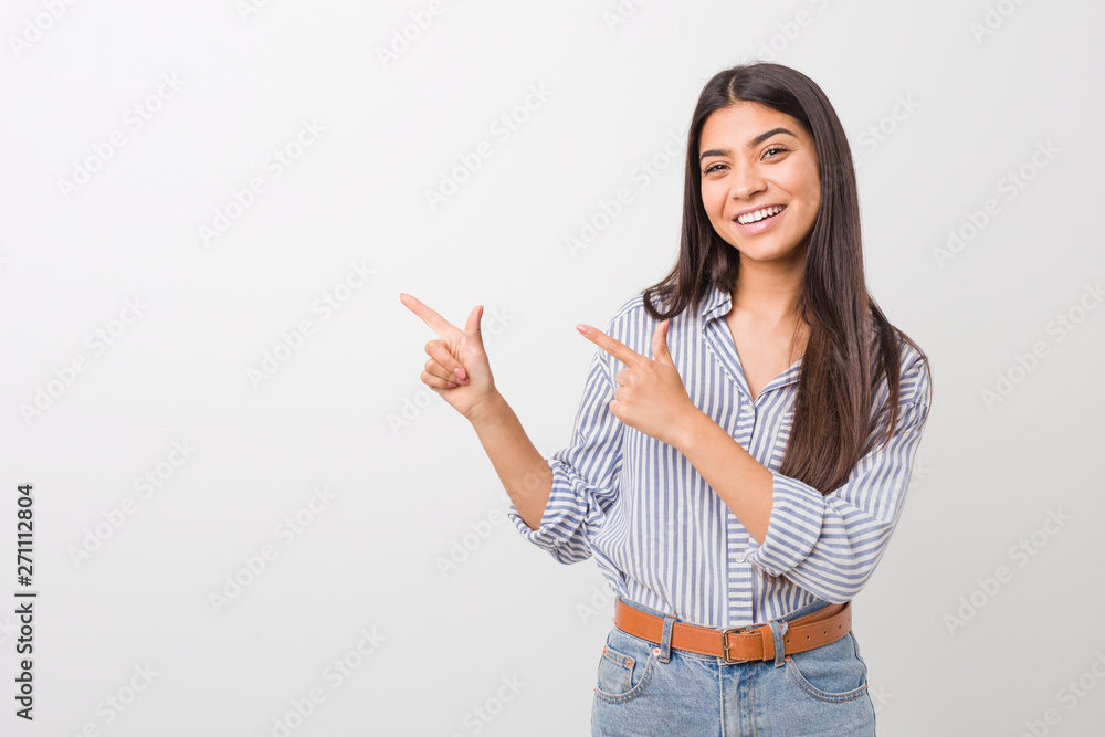 Young pretty arab woman pointing with forefingers to a copy space, expressing excitement and desire. Young pretty arab woman pointing with forefingers to a copy space, expressing excitement and desire.