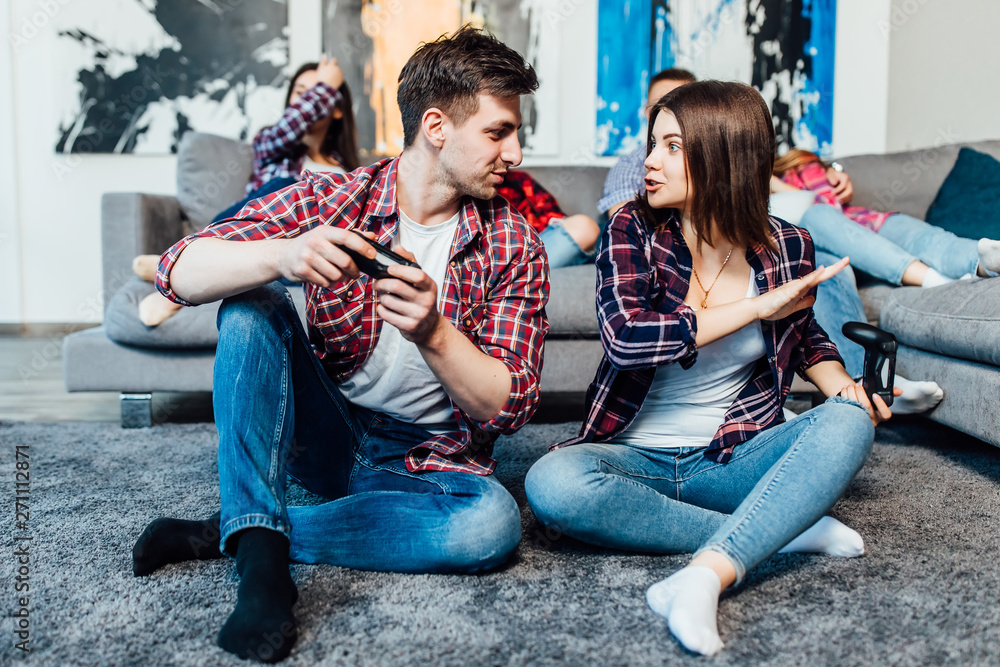 Two happy young friends holding joystick and playing videogame. Happy time.. Angty woman lose.. Two happy young friends holding joystick and playing videogame. Happy time.. Angty woman lose..