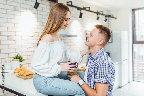 Romantic young couple drinking coffee together in the kitchen,having a great time together.