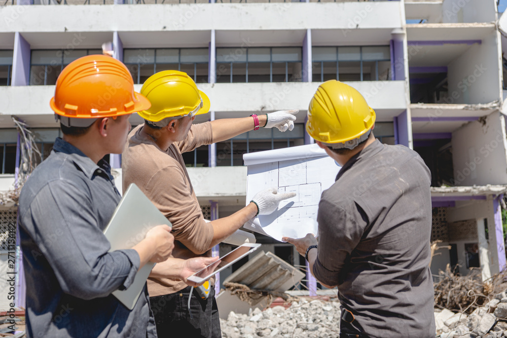 Fototapeta premium Engineer team and worker checking blueprint for emolition construction plan and inspect at the site.