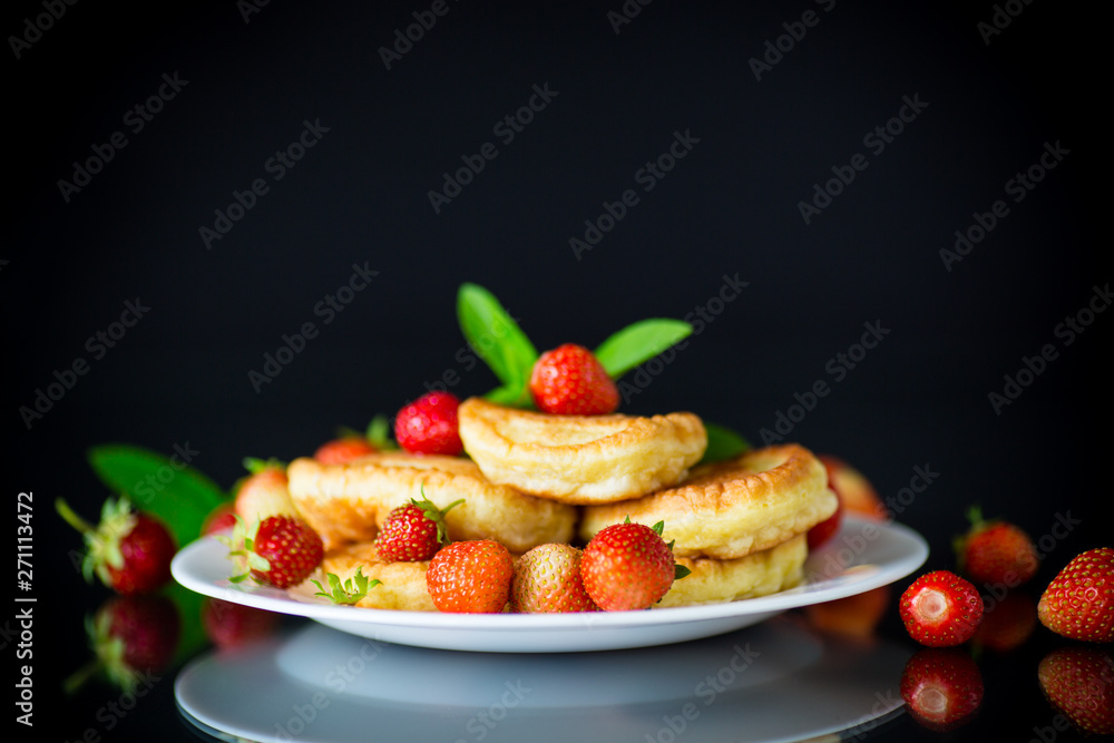 fried sweet pancakes with ripe strawberries in a plate fried sweet pancakes with ripe strawberries in a plate