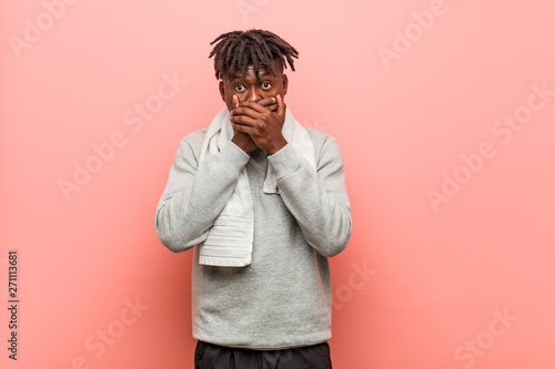 Young fitness african black man shocked covering mouth with hands.