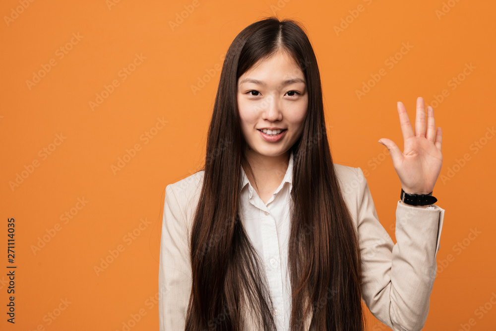 Young business chinese woman smiling cheerful showing number five with fingers. Young business chinese woman smiling cheerful showing number five with fingers.