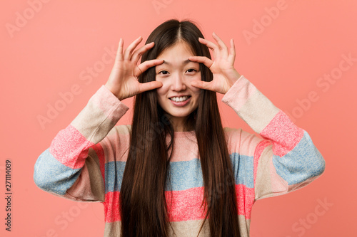 Tableau sur toile Young cool chinese woman keeping eyes opened to find a success opportunity